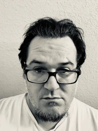 a black and white photo of a man with glasses